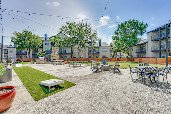 Outdoor courtyard with seating and fire pit at Carmel Creekside Apartments, Fort Worth