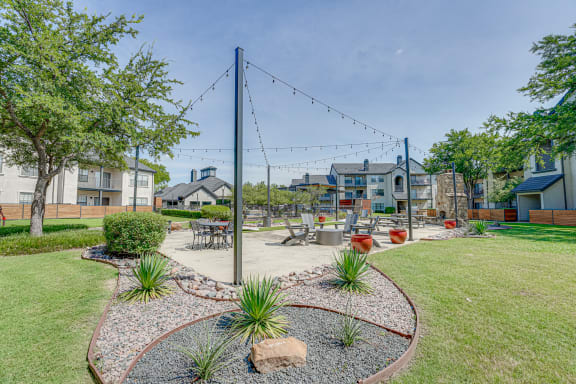 Outdoor courtyard with string lights and seating areas at Carmel Creekside Apartments, Texas, 76137