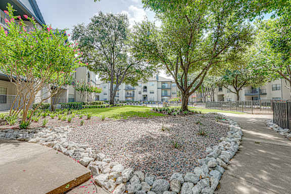Courtyard pathway with gravel landscaping and stone borders at Carmel Creekside Apartments, Fort Worth, 76137
