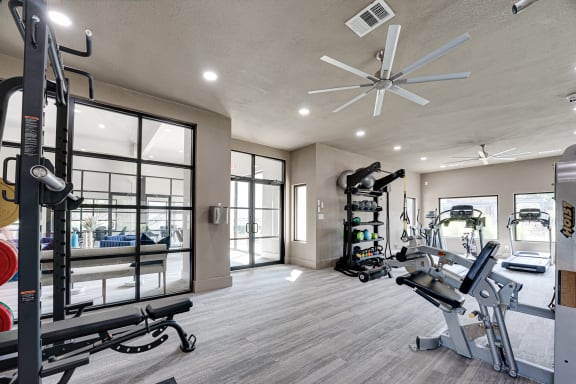 Spacious fitness center with exercise equipment and ceiling fan at Carmel Creekside Apartments, Fort Worth
