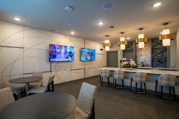A modern bar area with a round table and bar stools.