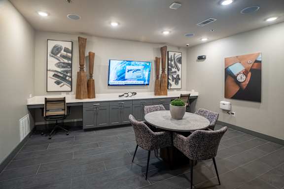A modern dining room with a round table and grey chairs.