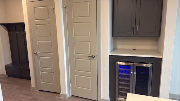 A kitchen with a wine cooler in the corner.