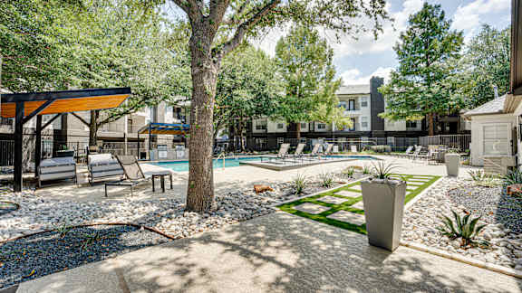A backyard with a pool and a tree at Knox Allen Station, Allen, TX