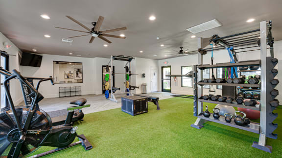 Gym with a green carpet floor and a ceiling fan at Knox Allen Station, Allen, TX
