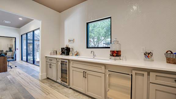 A kitchen with a white counter top and a window. at Knox Allen Station, Allen, TX, 75002