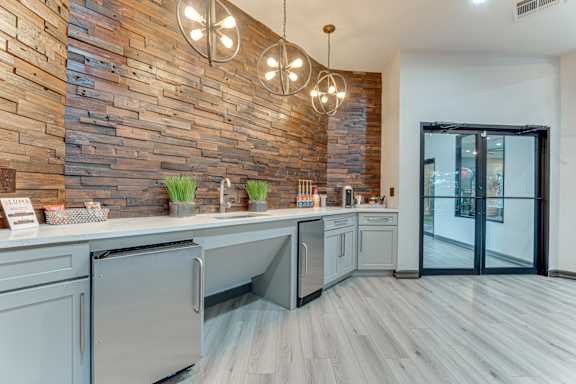 Clubhouse kitchen with wood accent wall and pendant lighting at Limestone Ranch Apartments, Texas, 75067