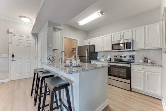 A kitchen with a bar area and stools.