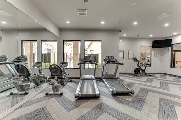 Fitness center with cardio equipment and mirrors at Limestone Ranch Apartments, Lewisville, 75067