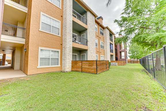 Apartment complex with a green lawn in front.