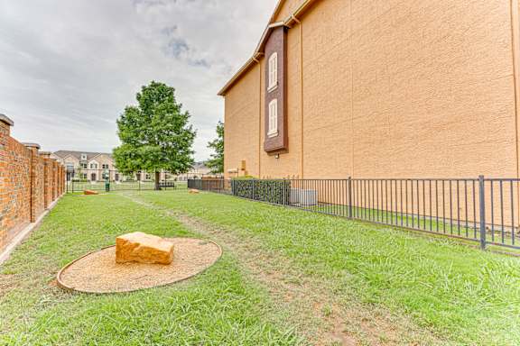 Fenced backyard with decorative rock feature at Limestone Ranch Apartments, Texas
