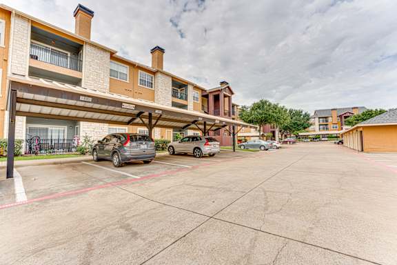 Covered carport parking area with resident vehicles at Limestone Ranch Apartments, Texas, 75067