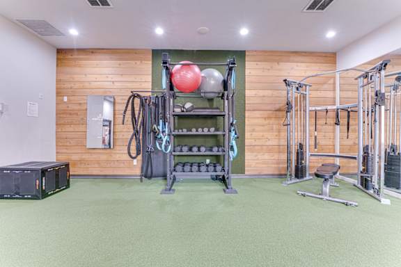 Fitness center with cable equipment and weight storage at Limestone Ranch Apartments, Lewisville, TX 75067