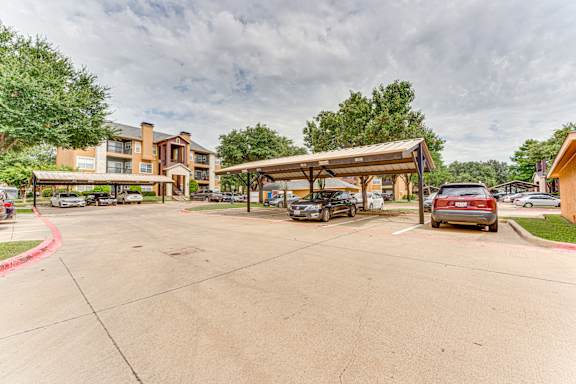 Covered carport parking with residential buildings at Limestone Ranch Apartments, Lewisville, 75067