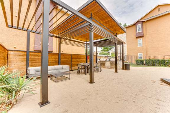 Covered outdoor lounge area with seating and dining space at Limestone Ranch Apartments, Texas, 75067