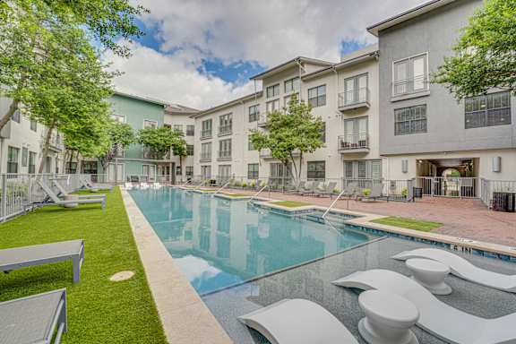 Swimming pool courtyard with modern apartment buildings at The Montrose Apartments, Dallas, TX 75204