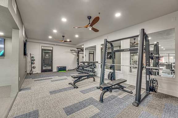 Fitness center with weight equipment and ceiling fans at The Montrose Apartments, Texas, 75204