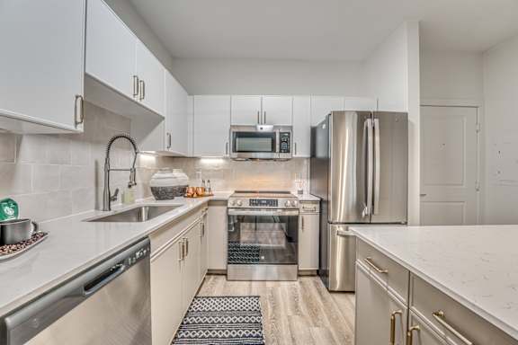 A modern kitchen with stainless steel appliances and white cabinets.
