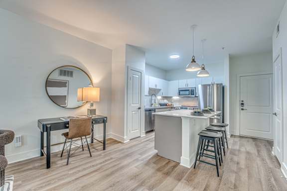 A kitchen with a bar stool and a table with a chair.