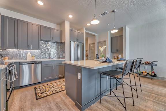 A kitchen with a large island and modern appliances.
