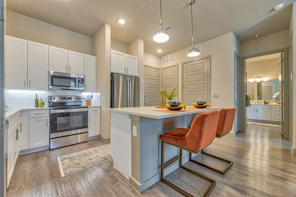 A kitchen with a table and chairs in the middle of it.