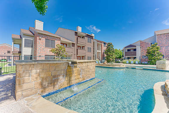 swimming pool in front of a building at Timberglen Apartments, Texas