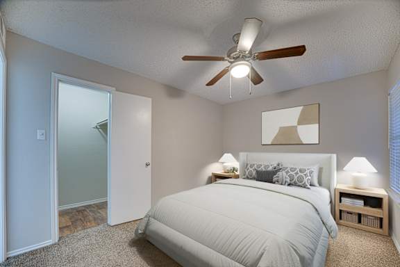 bedroom with a bed, two lamps at Timberglen Apartments, Texas
