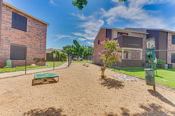 small tree is in the middle of a dirt area at Timberglen Apartments, Dallas, TX