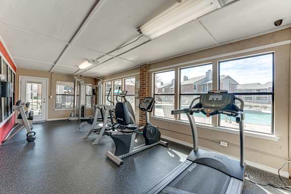 Fitness center with treadmill and recumbent bike at Towne Centre Village Apartments, Texas