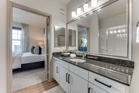 Bathroom with large mirror above the sink at Vine + Vail Townhomes and Apartments, Texas