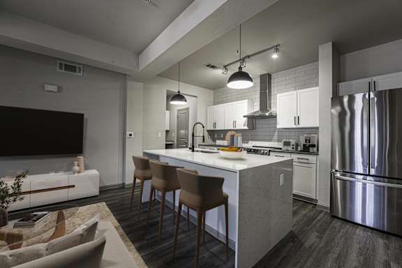 A modern kitchen with a large island and stainless steel appliances.
