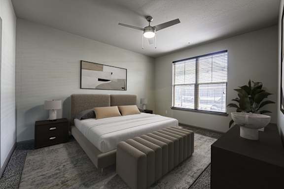A bedroom with a bed, nightstands, and a ceiling fan.