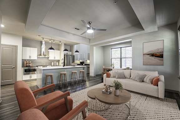 A modern living room with a kitchen area in the background.