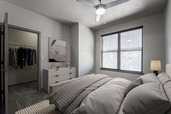 A bedroom with a large bed and a ceiling fan.