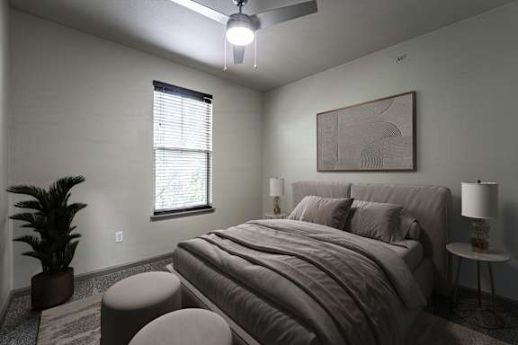 A bedroom with a large bed, a ceiling fan, and a potted plant.