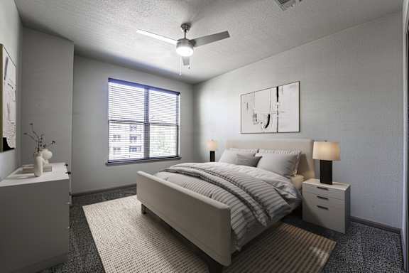 A bedroom with a bed, nightstands, and a ceiling fan.