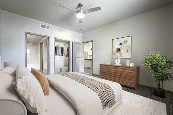 A bedroom with a large bed and a ceiling fan.