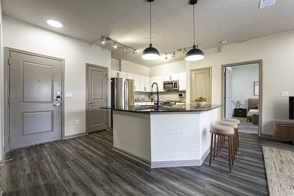 A kitchen with a white counter and a refrigerator.