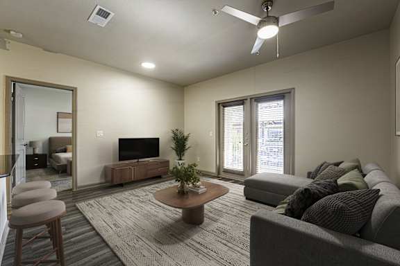 A living room with a grey couch, a coffee table, and a television.