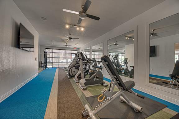 Fitness center with mirrors at Vue Live Oak Apartments, Texas