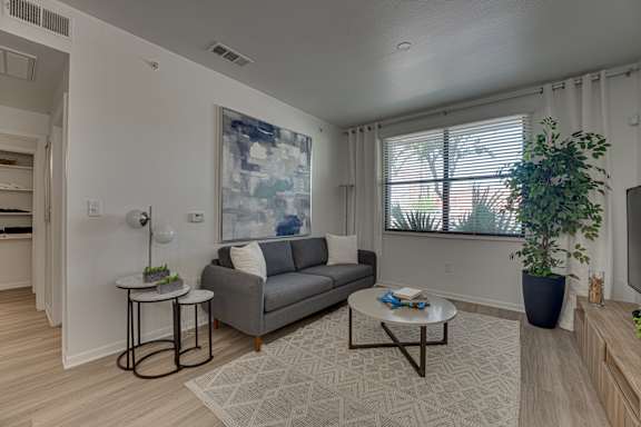 Living room with modern furniture and abstract artwork at Vue Live Oak Apartments, Dallas, TX