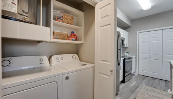 Laundry room with washer dryer and cabinetry at Carmel Creekside Apartments, Fort Worth, TX 76137