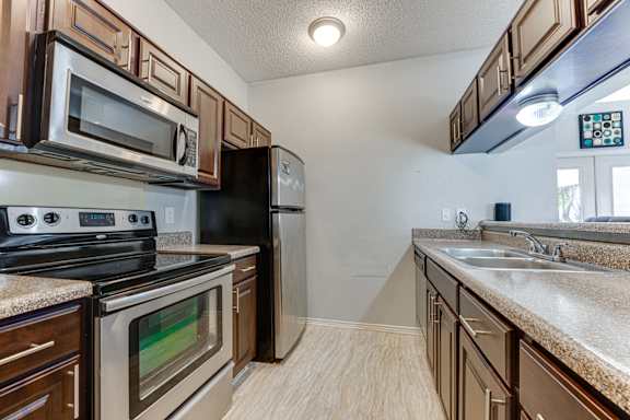 A kitchen with a black refrigerator, stove, and oven. at Wilson Crossing, Cedar Hill, 75104