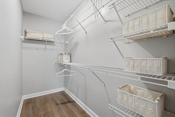 A white walk in closet with shelves and baskets.