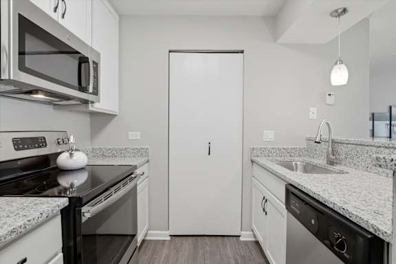 A modern kitchen with granite countertops and stainless steel appliances.