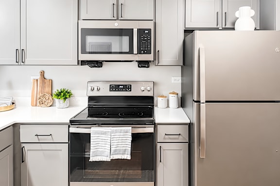A modern kitchen with a stove, oven, and refrigerator.