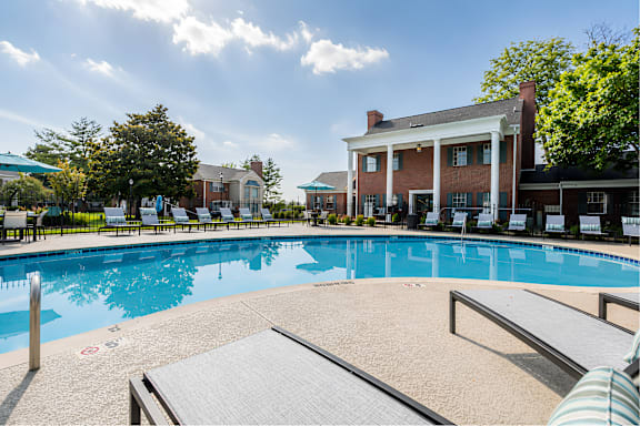 A large outdoor swimming pool with a building in the background.