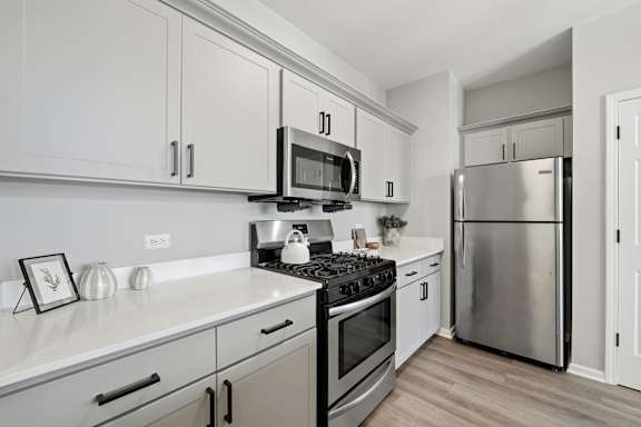 A kitchen with white cabinets and stainless steel appliances.