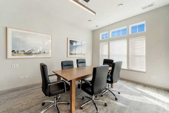 A conference room with a large table and chairs.