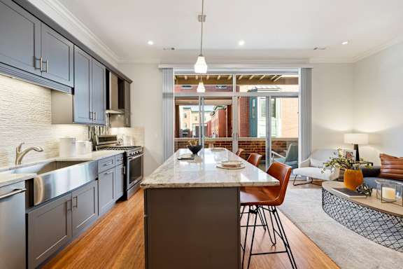 A modern kitchen with a large island and stainless steel appliances.